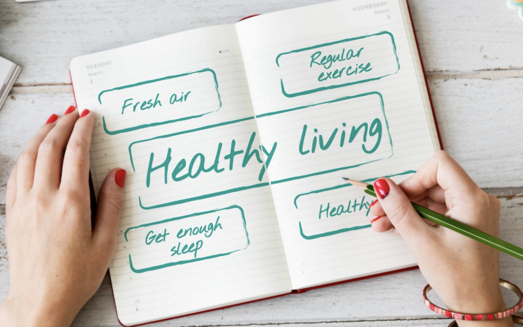 An open notepad on the table with "healthy living" written in the middle. The text is surrounded by four boxes with the text "Fresh air", "Regular exercise", "get enough sleep" and "healthy"